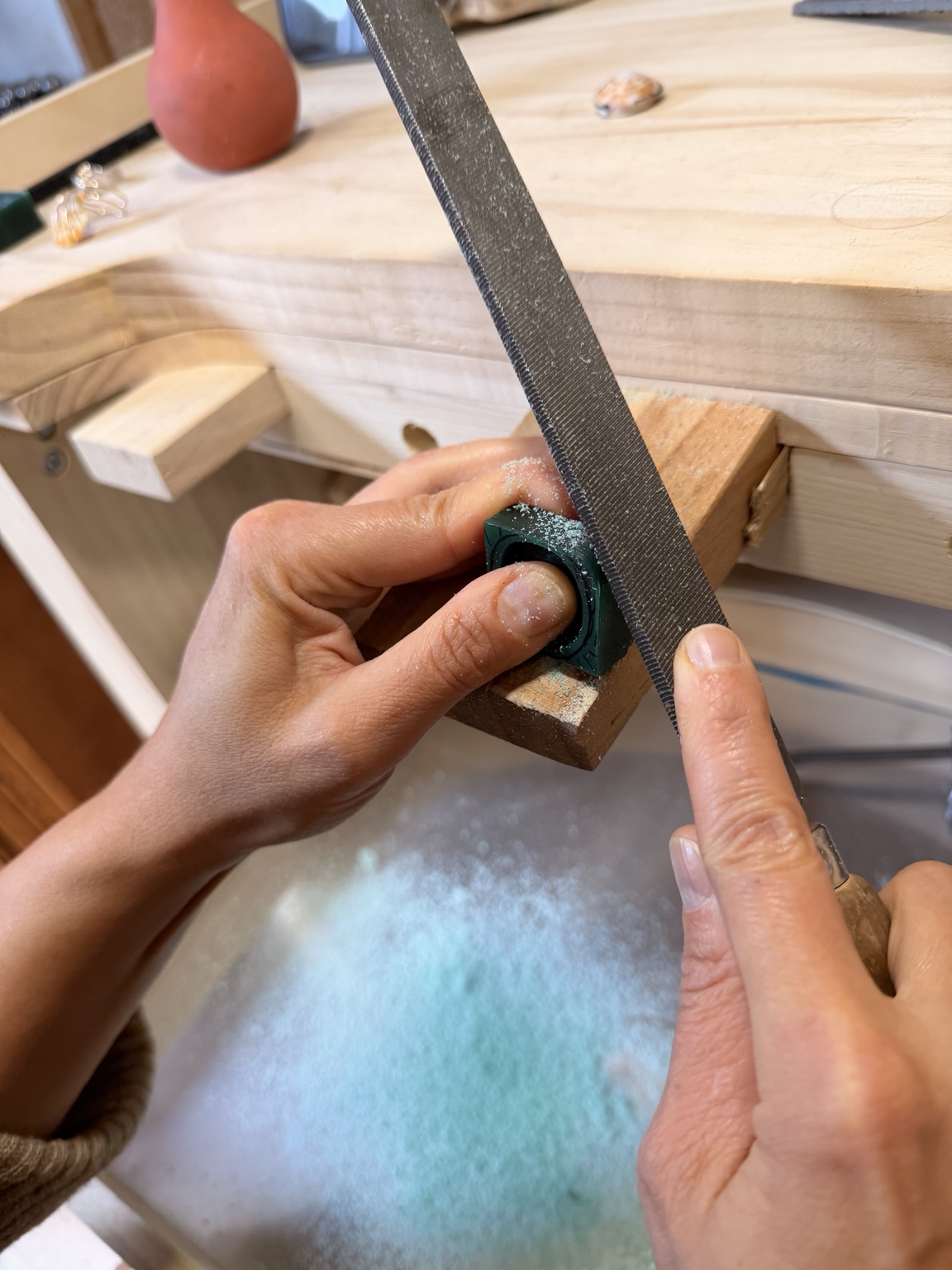 Ein grüner Wachsring wird sorgfältig in Form gefeilt