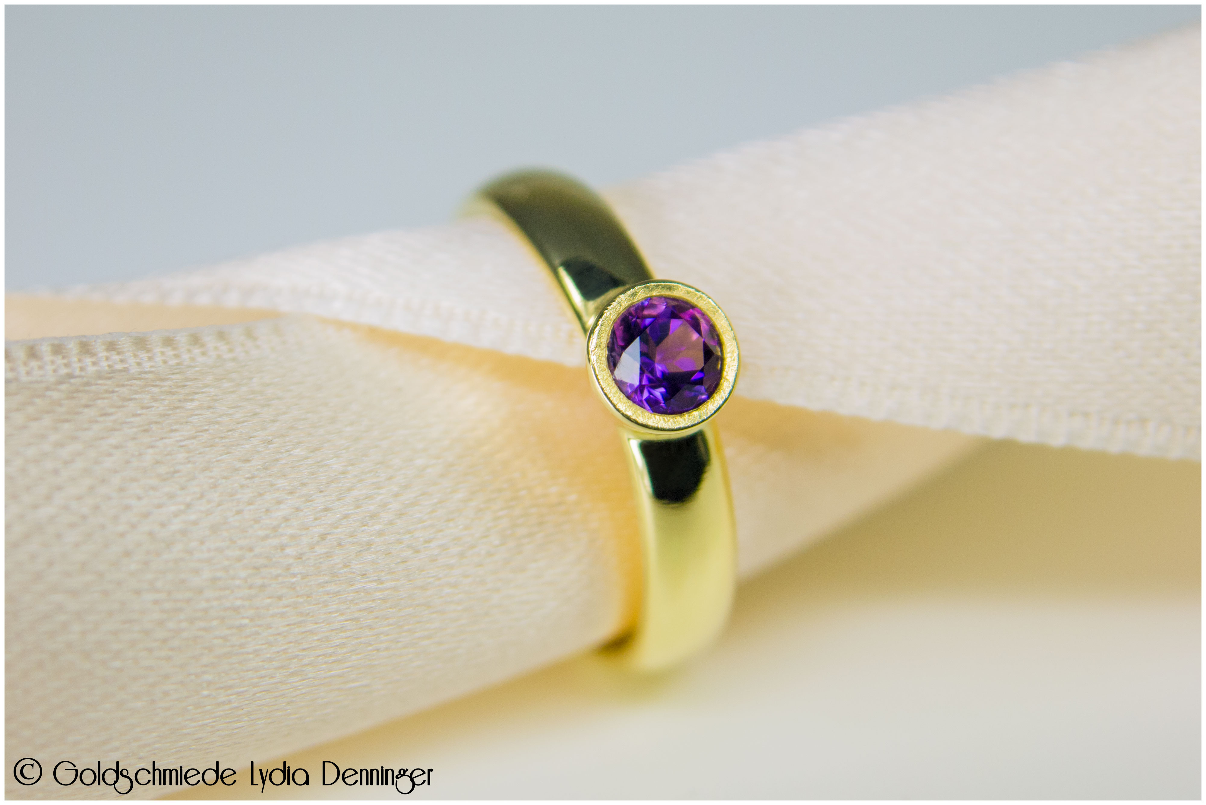 Ring 585/- Gelbgold, in die Solitärfassung wurde ein Amethyst eingebettet und die Glanzkante wurde eismattiert